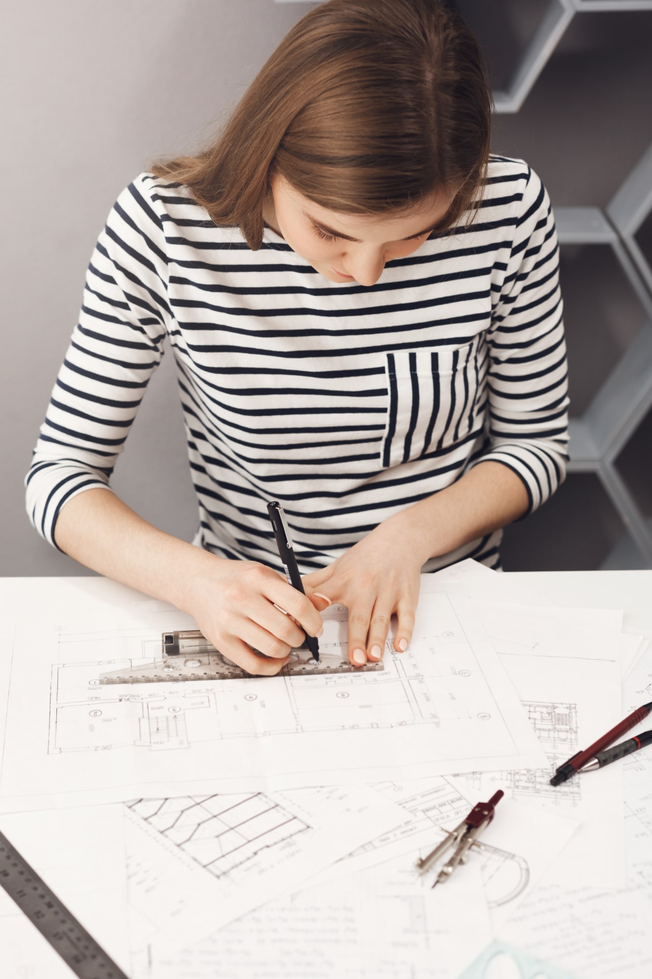 close-up-young-professional-handsome-skinny-dark-haired-girl-striped-shirt-working-new-blueprint-future-team-project-min